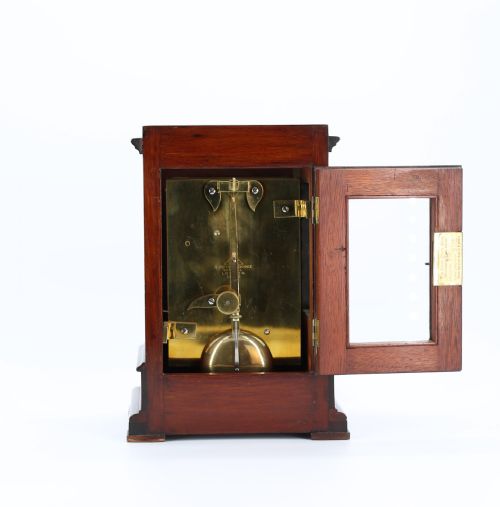 fig 1. A Victorian mahogany five-glass library clock featuring a silvered dial with Roman numerals and engraved corner spandrels.