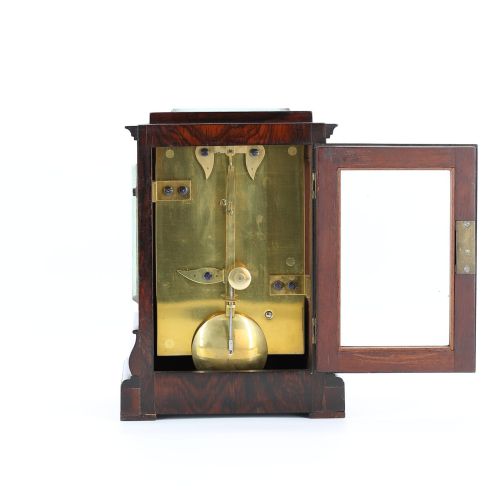 fig 1. An antique mahogany five-glass library clock featuring a silvered dial with Roman numerals, corner engravings, and a stepped plinth base.