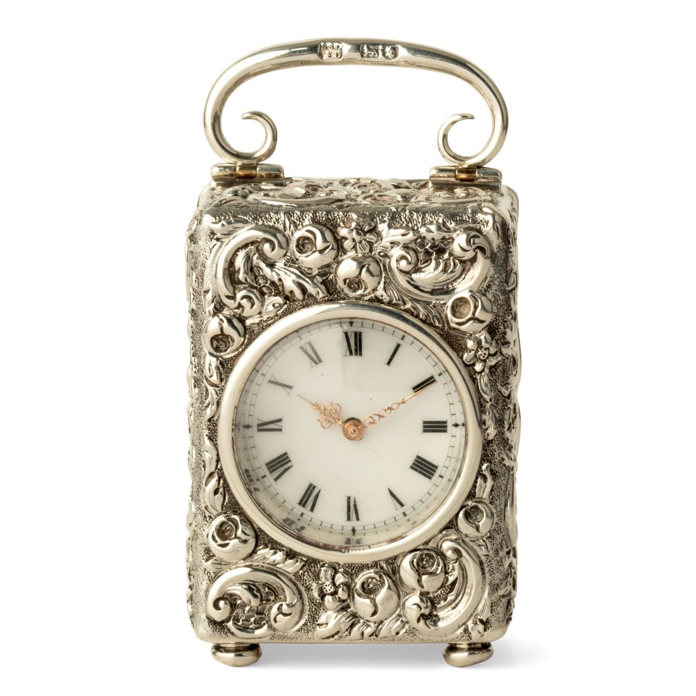 A CHASED SILVER CASED TIMEPIECE BOUDOIR CARRIAGE CLOCK