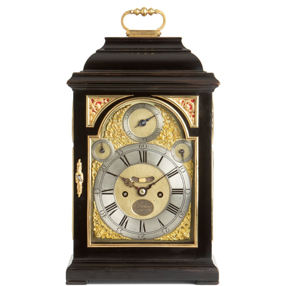 An 18th-century Georgian ebonised table clock featuring a bell top case, brass handle, and silvered chapter ring dial.