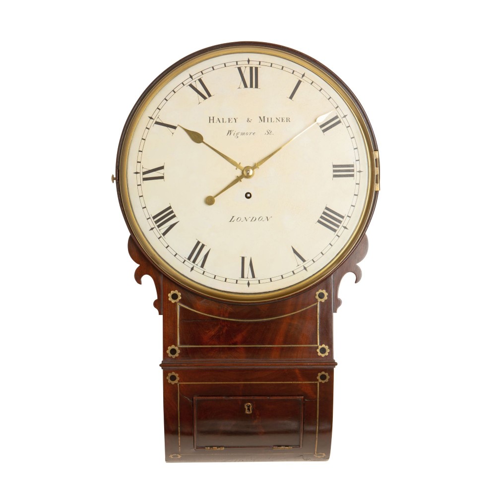 An antique Regency mahogany drop dial wall clock featuring a cream dial signed Haley and Milner London with Roman numerals and brass inlay.