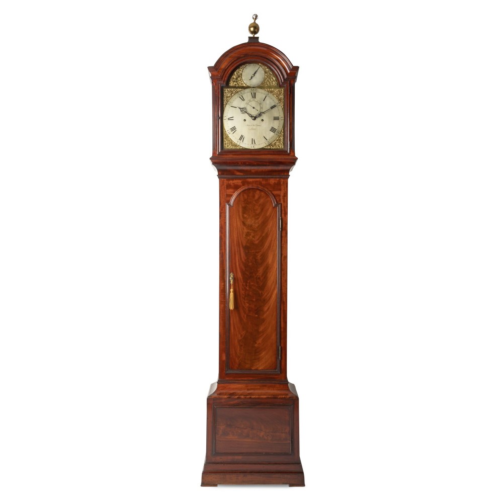 An eighteenth-century Georgian mahogany eight-day longcase clock featuring an arched hood with a brass finial and a flame mahogany veneer trunk door.