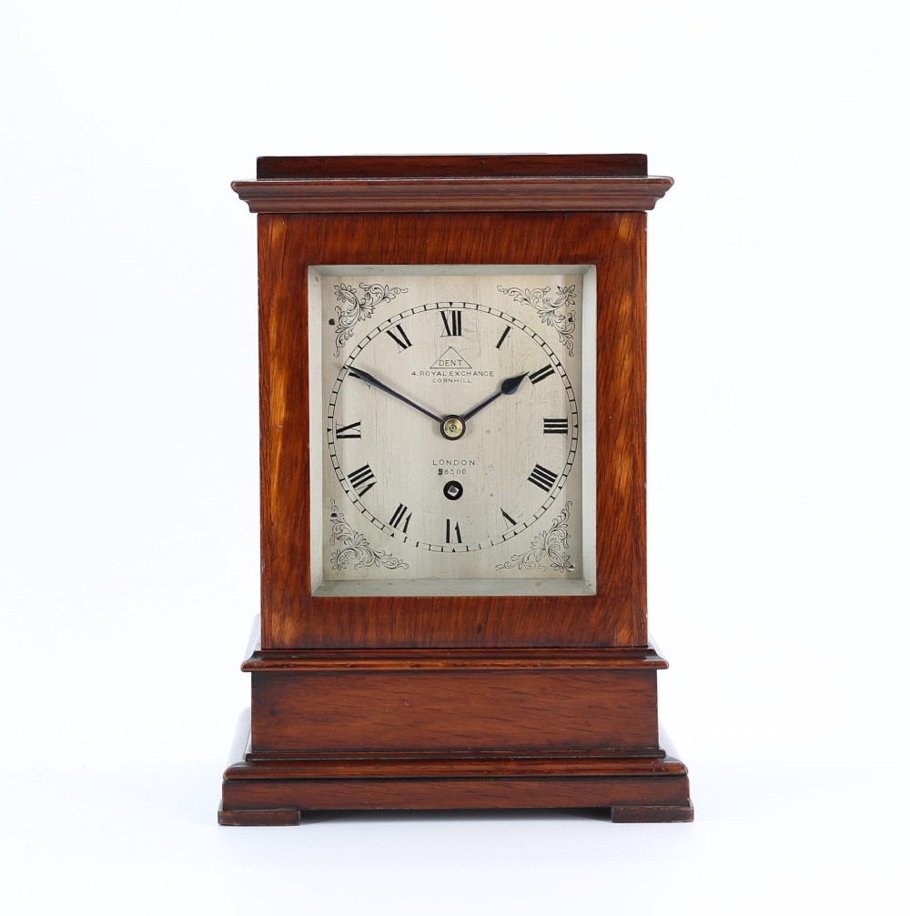 A Victorian mahogany five-glass library clock featuring a silvered dial with Roman numerals and engraved corner spandrels.