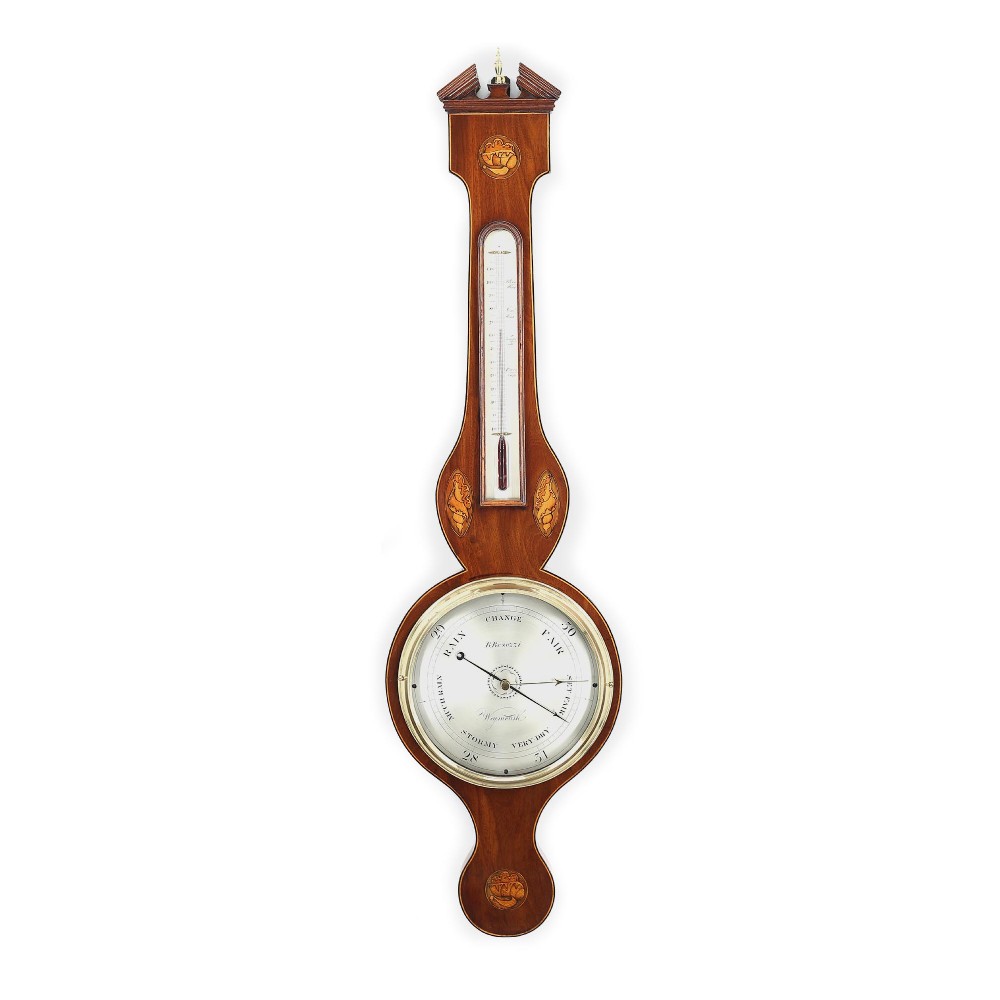 An antique Georgian mahogany wheel barometer featuring shell marquetry inlays, a thermometer tube, and a circular dial with brass bezel.