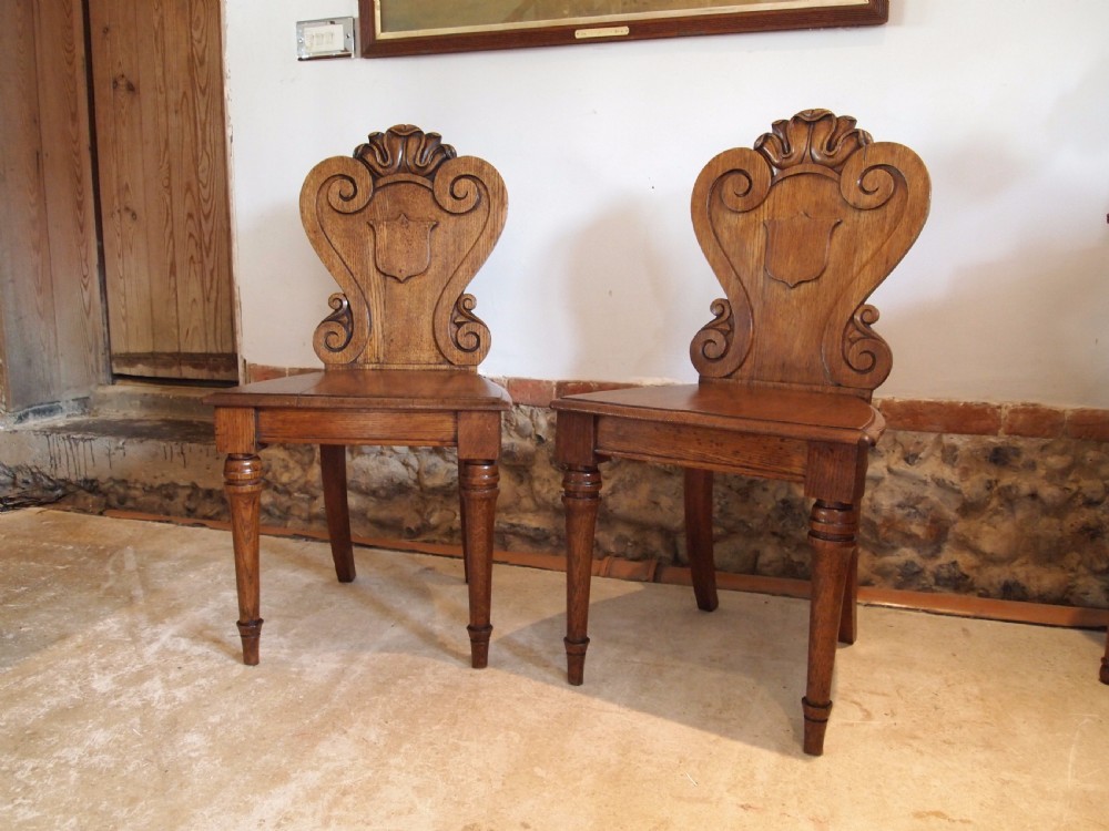 Chairs pair of William IV carved Oak hall chairs c1835 View II