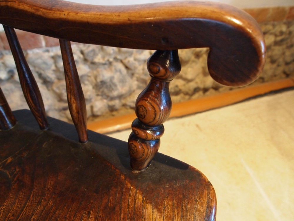 A dark brown Victorian Lincolnshire Windsor armchair featuring a turned spindle back, shaped crest rail, curved armrests, and turned legs with stretchers. View VIII