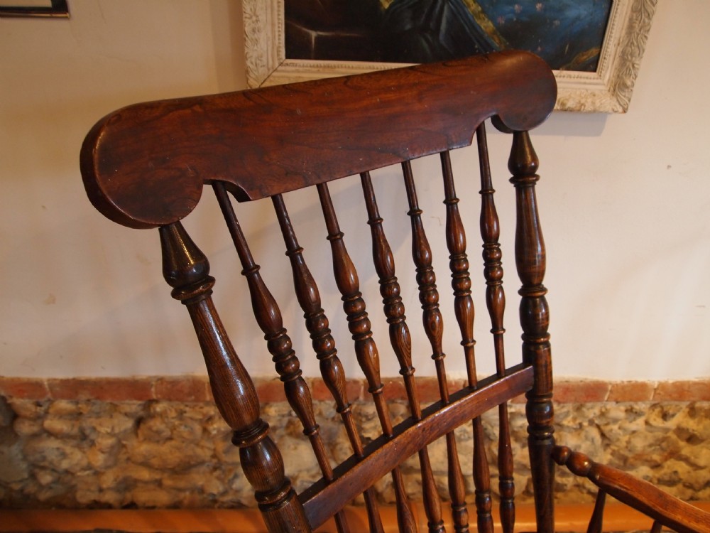 A dark brown Victorian Lincolnshire Windsor armchair featuring a turned spindle back, shaped crest rail, curved armrests, and turned legs with stretchers. View IX