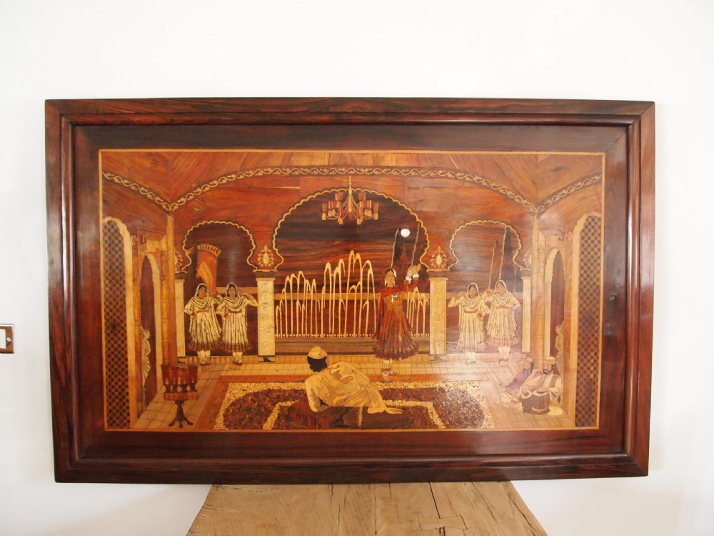A large rectangular Indian specimen wood marquetry panel depicting a detailed court performance scene framed in dark polished wood.