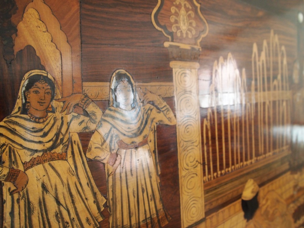 A large rectangular Indian specimen wood marquetry panel depicting a detailed court performance scene framed in dark polished wood. View IV