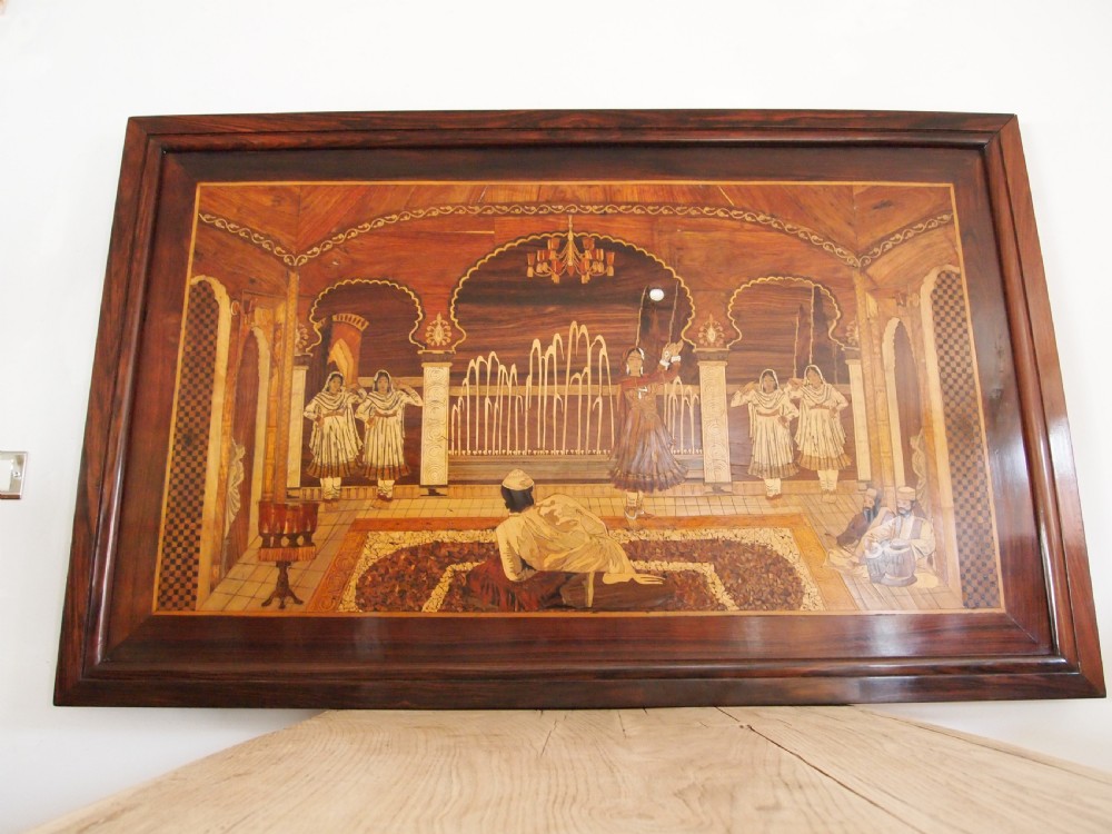 A large rectangular Indian specimen wood marquetry panel depicting a detailed court performance scene framed in dark polished wood. View VII