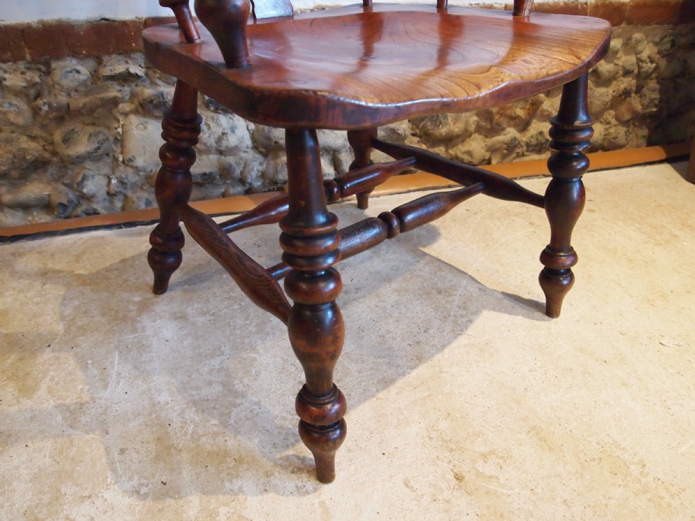 A Victorian wooden Windsor armchair with a high hoop back, central pierced splat, turned spindles, and turned legs with stretchers. View II