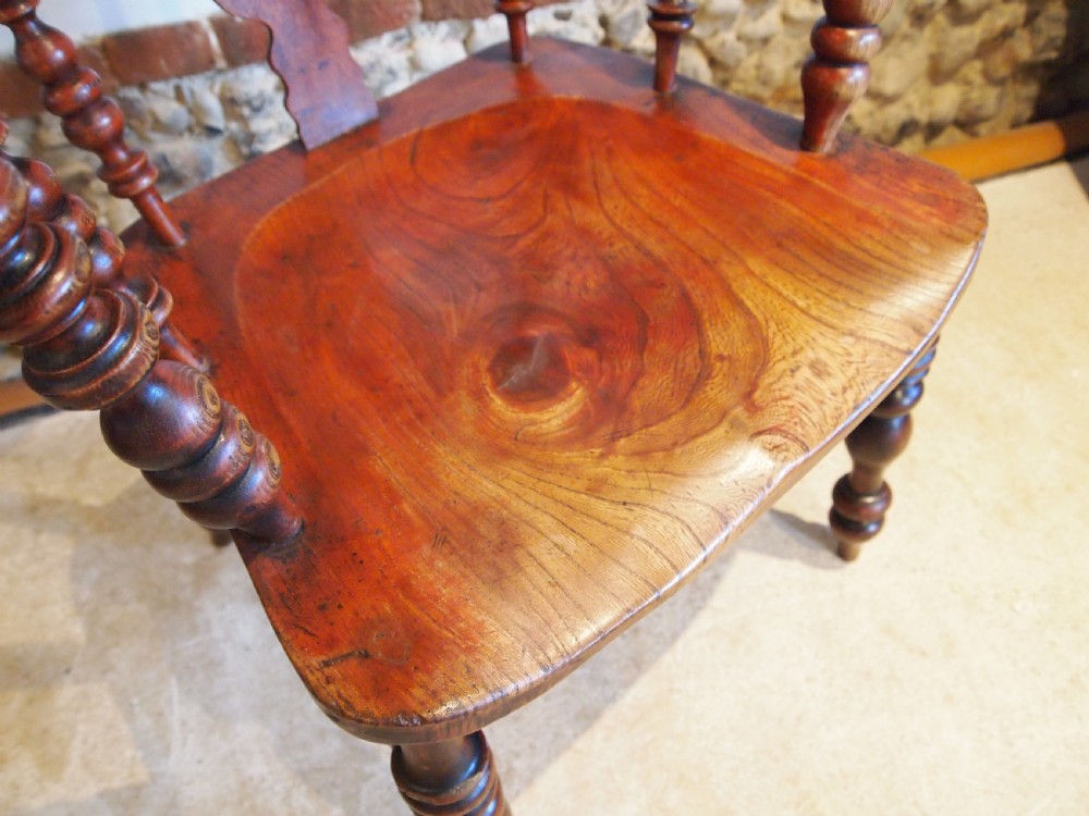 A Victorian wooden Windsor armchair with a high hoop back, central pierced splat, turned spindles, and turned legs with stretchers. View III