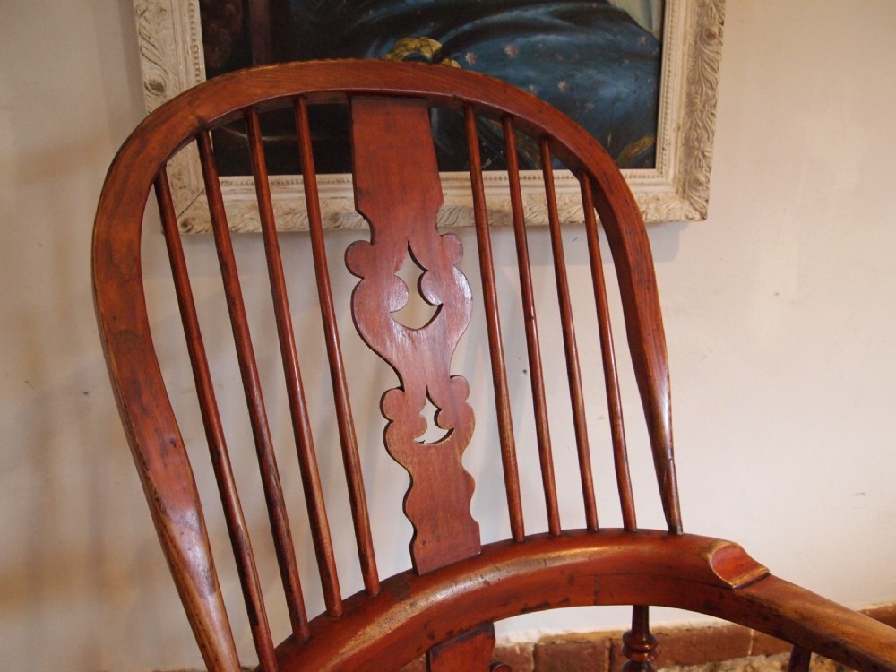 A Victorian wooden Windsor armchair with a high hoop back, central pierced splat, turned spindles, and turned legs with stretchers. View V