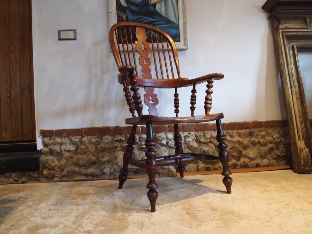 A Victorian wooden Windsor armchair with a high hoop back, central pierced splat, turned spindles, and turned legs with stretchers. View VII
