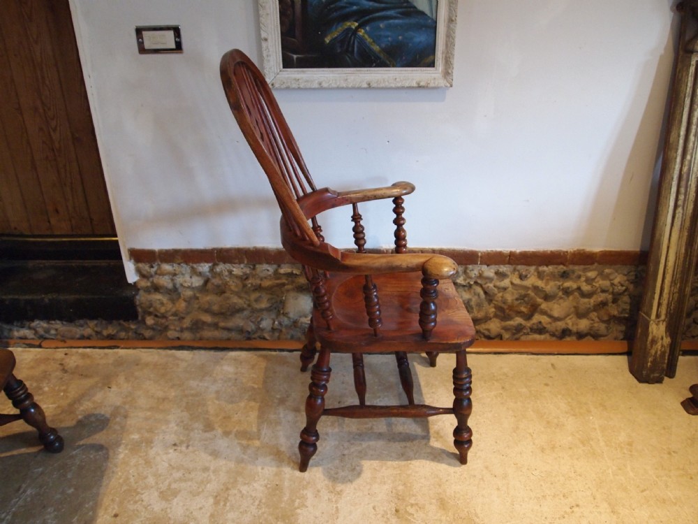 A Victorian wooden Windsor armchair with a high hoop back, central pierced splat, turned spindles, and turned legs with stretchers. View IX