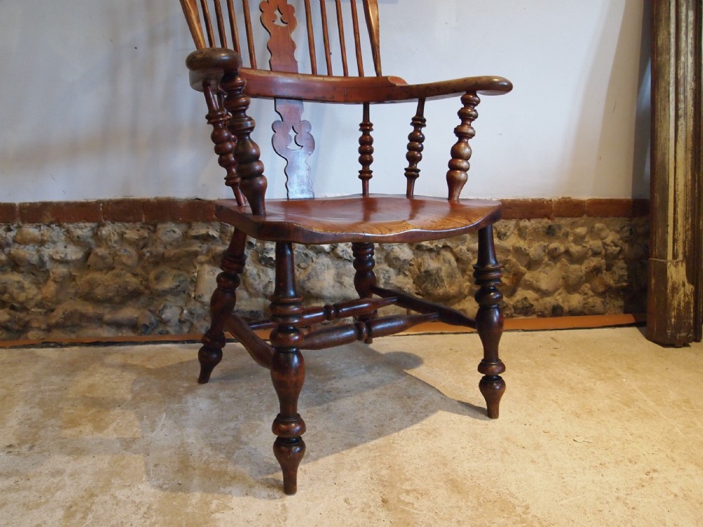 A Victorian wooden Windsor armchair with a high hoop back, central pierced splat, turned spindles, and turned legs with stretchers. View X