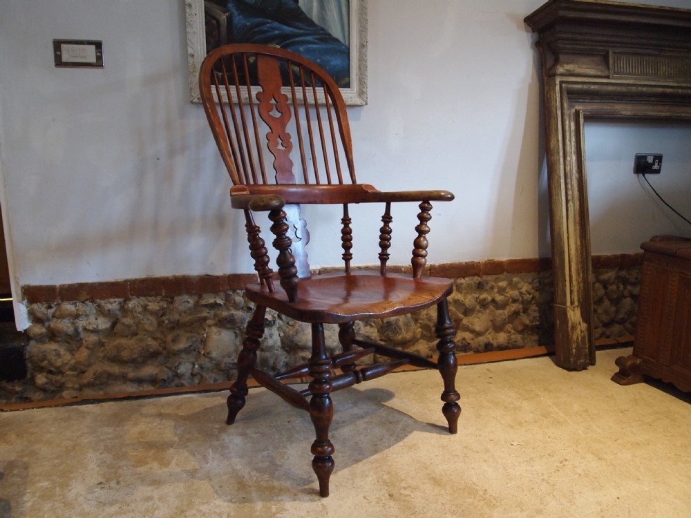 A Victorian wooden Windsor armchair with a high hoop back, central pierced splat, turned spindles, and turned legs with stretchers. View XII