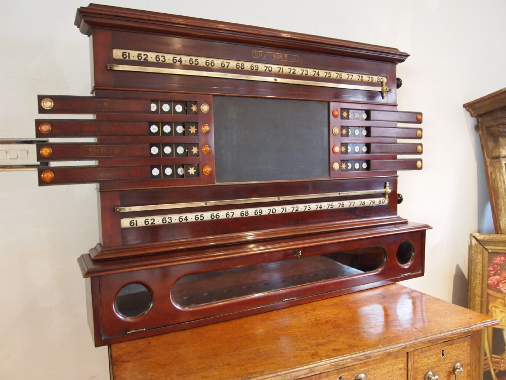 A Victorian mahogany snooker scoreboard featuring brass tracking rails, numbered rollers, a central chalkboard, and a glass-fronted lower cabinet. View VII