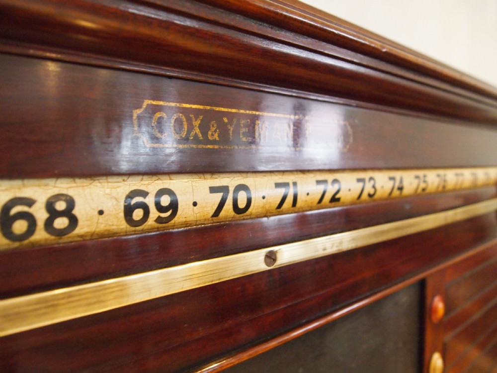 A Victorian mahogany snooker scoreboard featuring brass tracking rails, numbered rollers, a central chalkboard, and a glass-fronted lower cabinet. View X