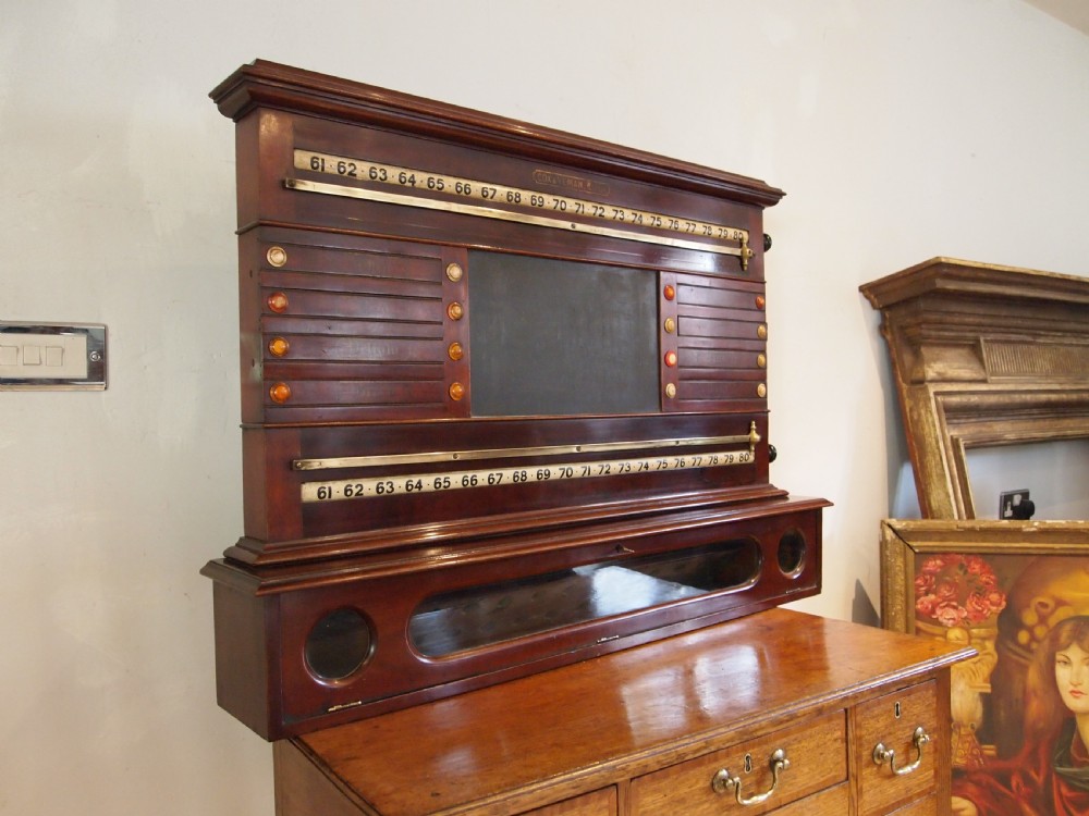 A Victorian mahogany snooker scoreboard featuring brass tracking rails, numbered rollers, a central chalkboard, and a glass-fronted lower cabinet. View XI