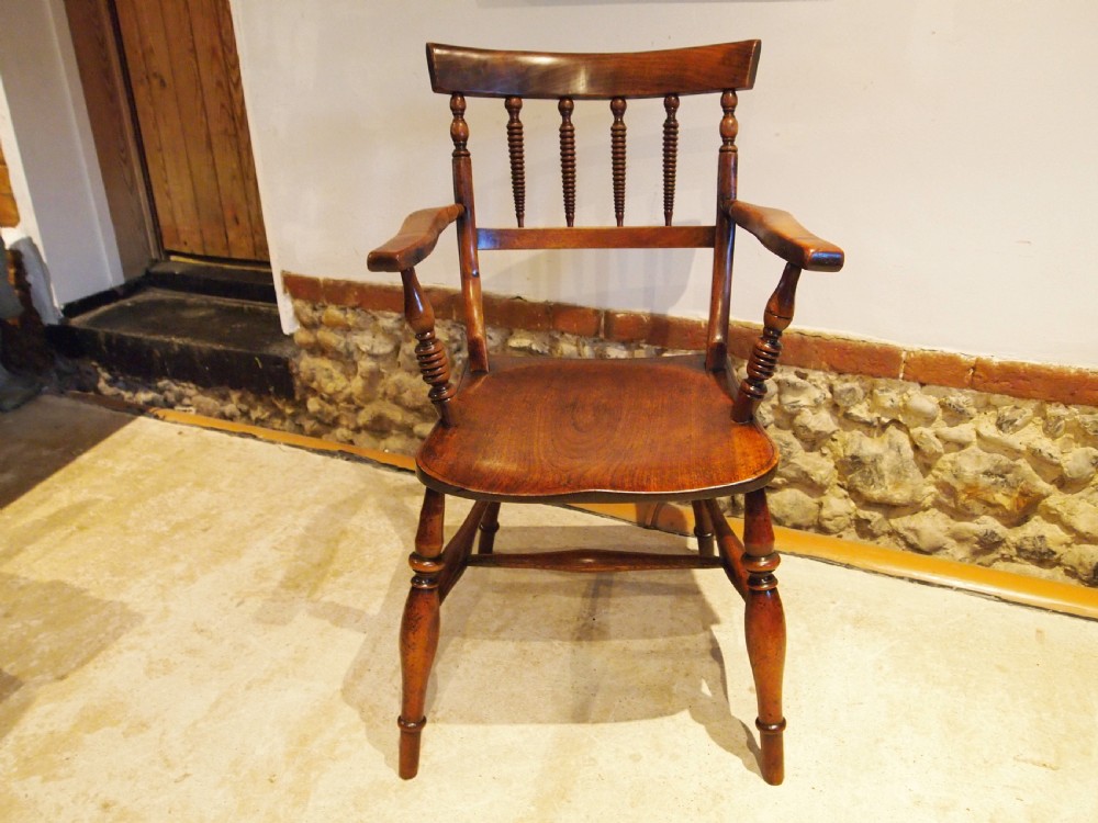 A Victorian wooden Windsor armchair with turned back spindles, shaped armrests, a solid timber seat, and turned legs. View XII