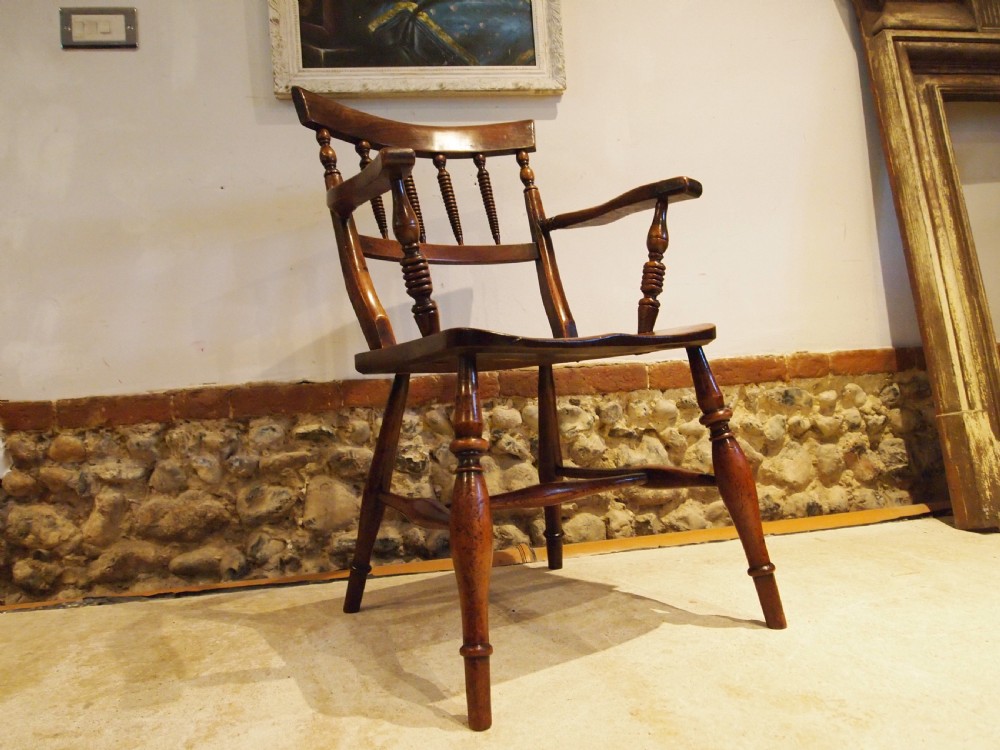 A Victorian wooden Windsor armchair with turned back spindles, shaped armrests, a solid timber seat, and turned legs. View XIV