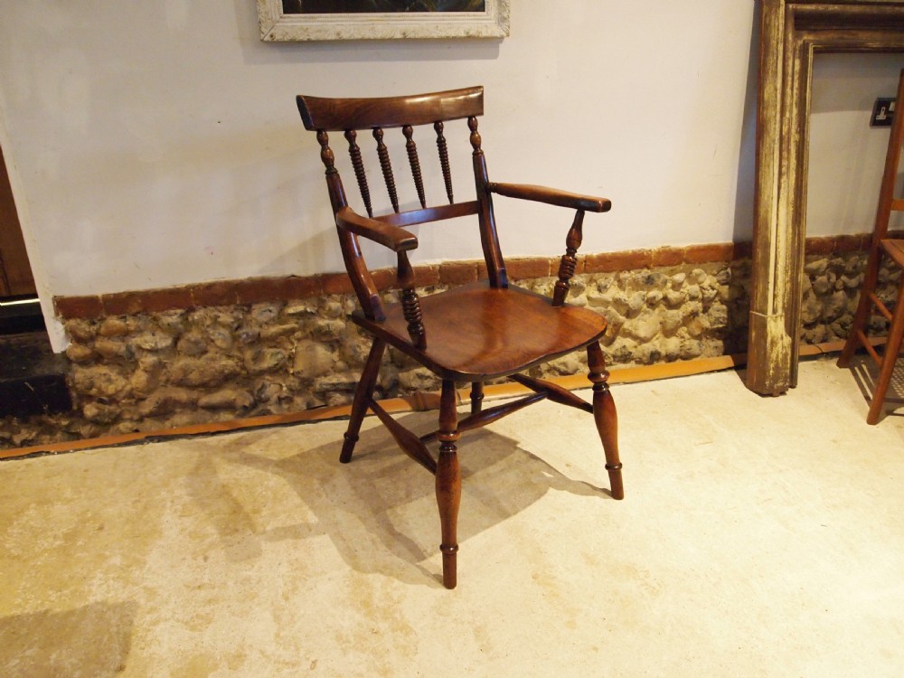 A Victorian wooden Windsor armchair with turned back spindles, shaped armrests, a solid timber seat, and turned legs. View XV