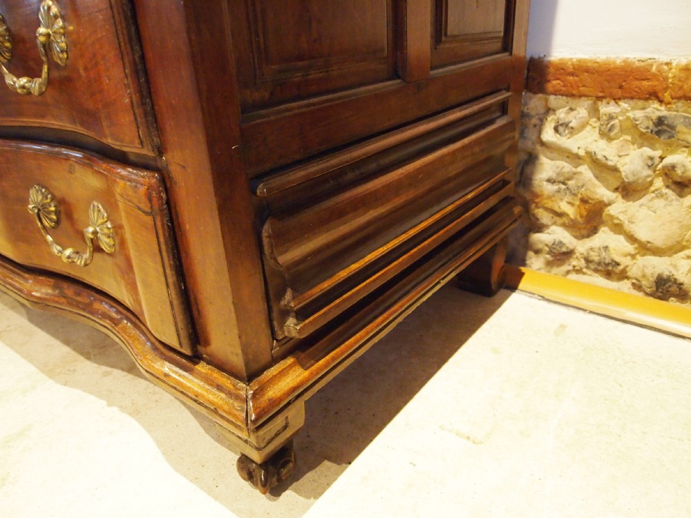 An 18th-century French walnut slant-front bureau desk featuring three wide drawers with ornamental brass handles and keyhole escutcheons. View V