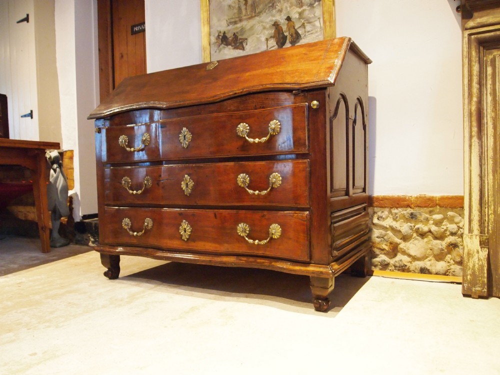 An 18th-century French walnut slant-front bureau desk featuring three wide drawers with ornamental brass handles and keyhole escutcheons. View IX
