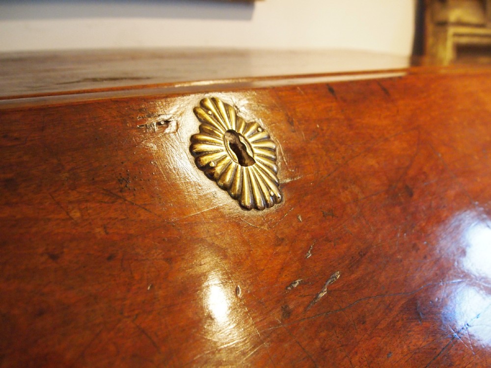 An 18th-century French walnut slant-front bureau desk featuring three wide drawers with ornamental brass handles and keyhole escutcheons. View XII