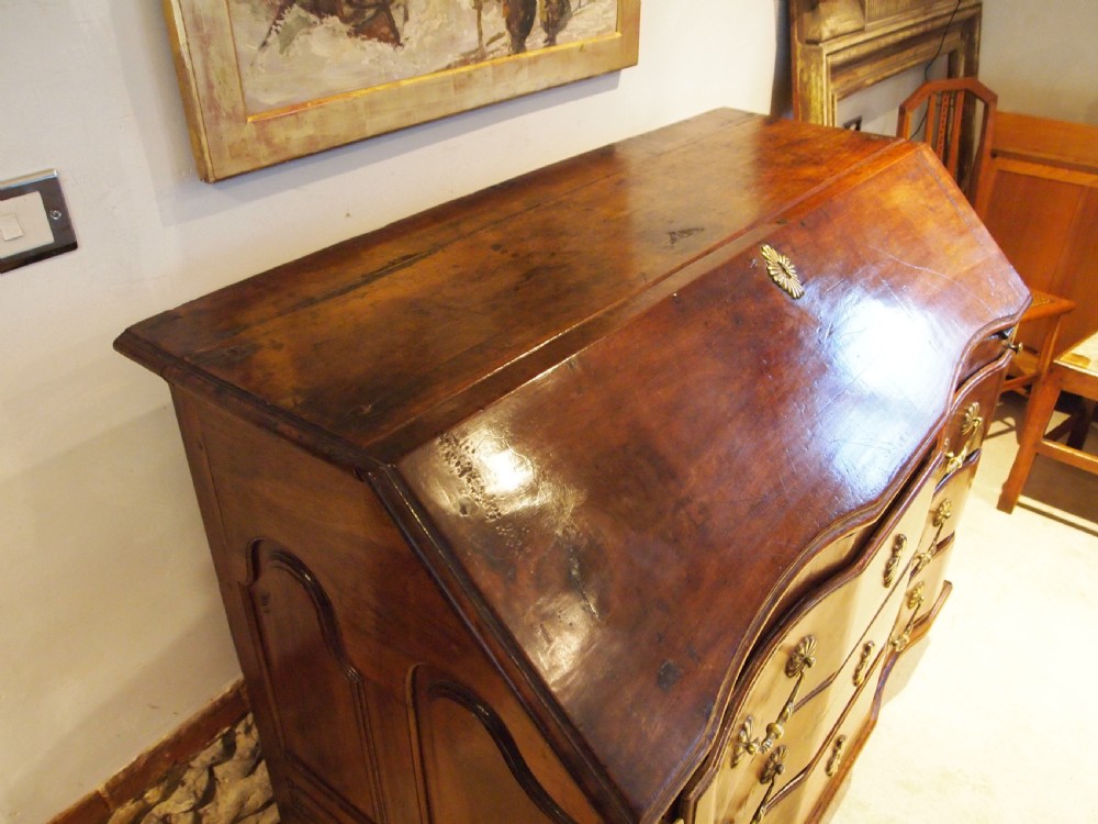 An 18th-century French walnut slant-front bureau desk featuring three wide drawers with ornamental brass handles and keyhole escutcheons. View XIII