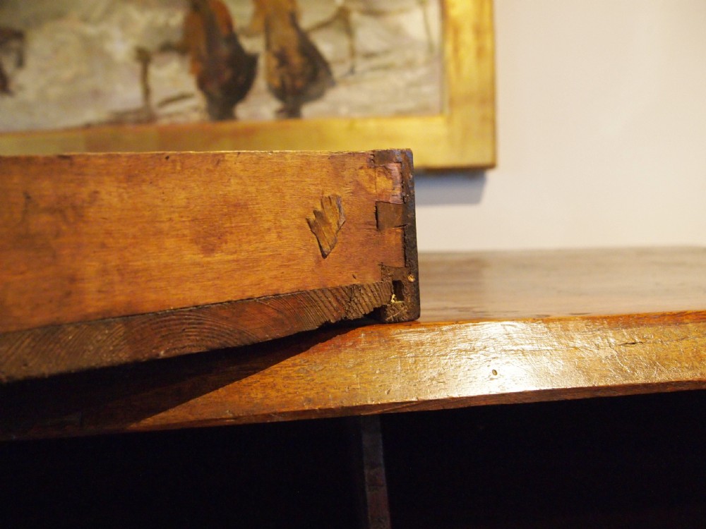An 18th-century French walnut slant-front bureau desk featuring three wide drawers with ornamental brass handles and keyhole escutcheons. View XVI