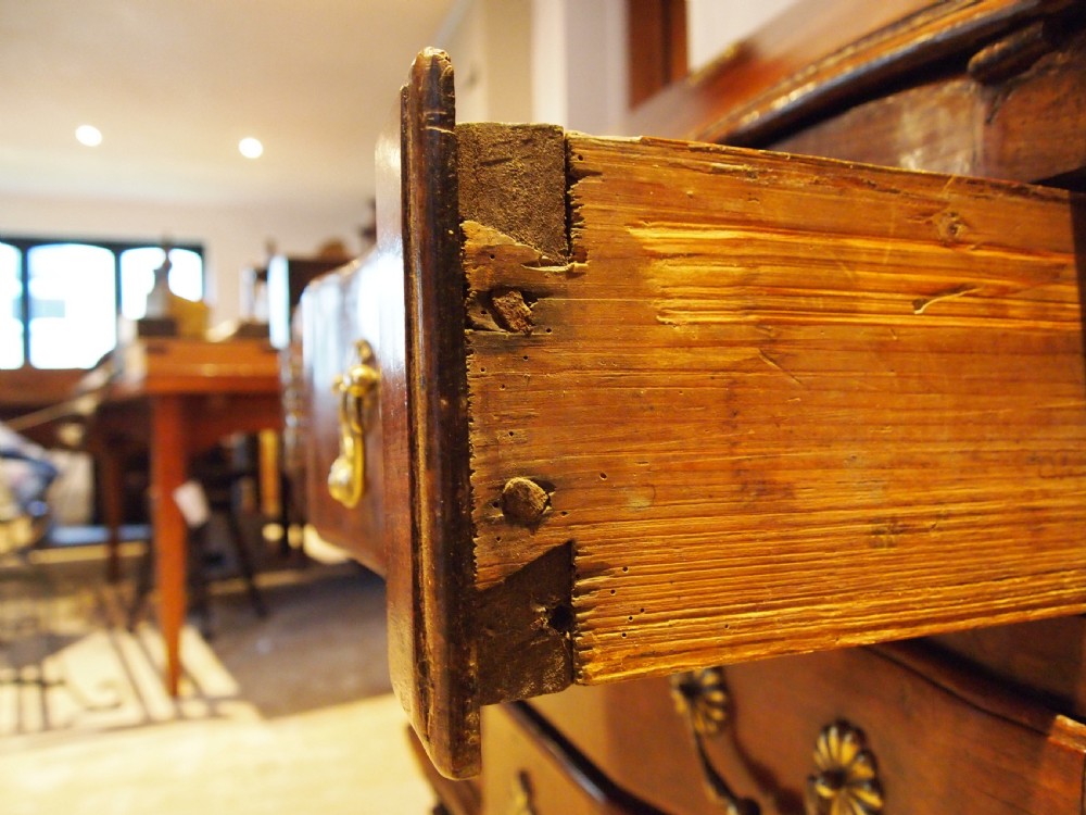 An 18th-century French walnut slant-front bureau desk featuring three wide drawers with ornamental brass handles and keyhole escutcheons. View XVII