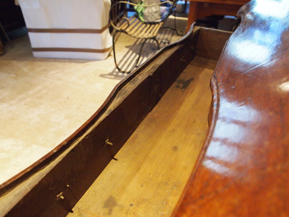 An 18th-century French walnut slant-front bureau desk featuring three wide drawers with ornamental brass handles and keyhole escutcheons. View XVIII