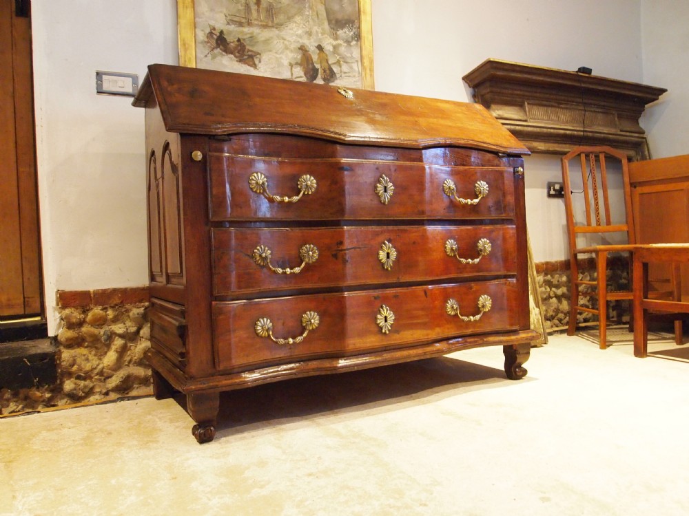 An 18th-century French walnut slant-front bureau desk featuring three wide drawers with ornamental brass handles and keyhole escutcheons. View XX