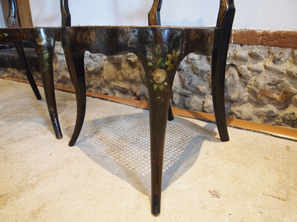 A pair of black Victorian side chairs featuring hand-painted floral details, balloon backrests, and woven cane seats. View VII