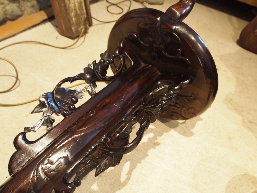 A tall early 20th-century Burmese standard lamp crafted from dark padouk wood, featuring intricate high-relief carving along the entire column and base. View VII