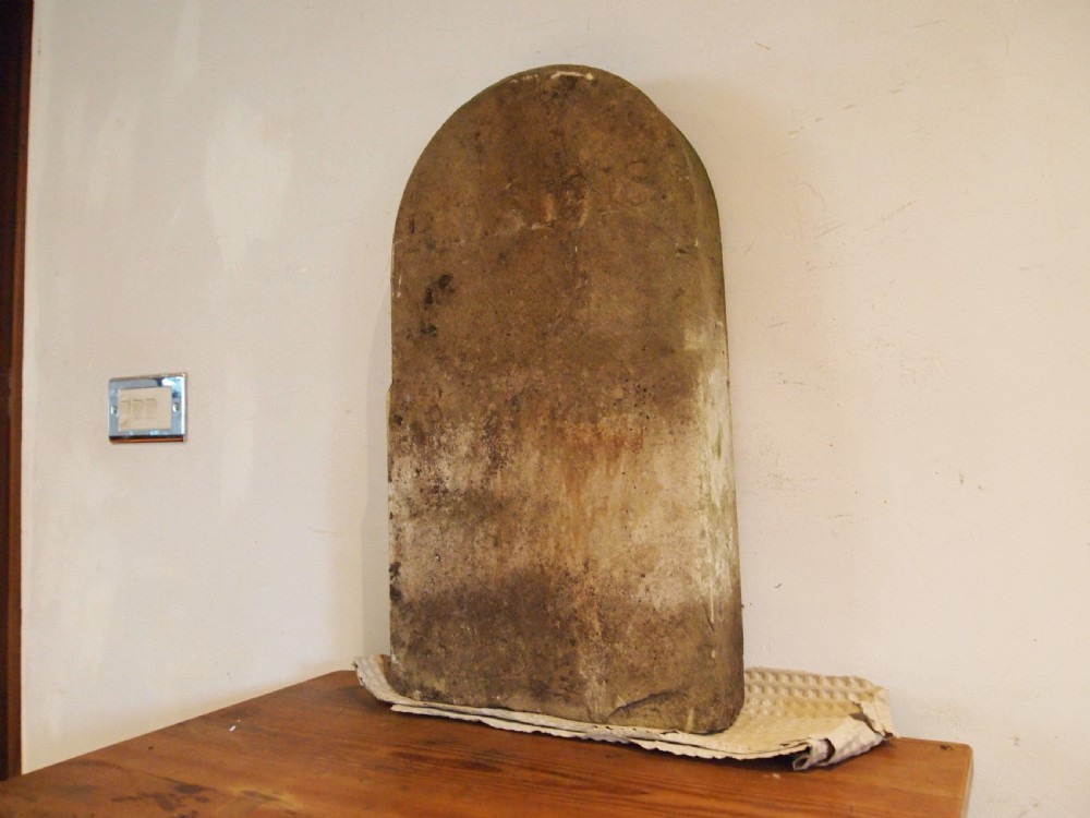 An arched top York stone headstone dated 1918 with hand-carved initials and weathered buff surface. View III