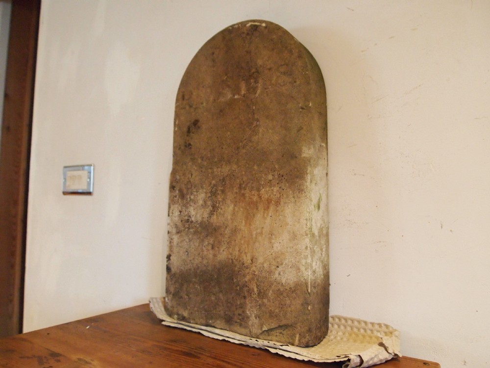 An arched top York stone headstone dated 1918 with hand-carved initials and weathered buff surface. View V