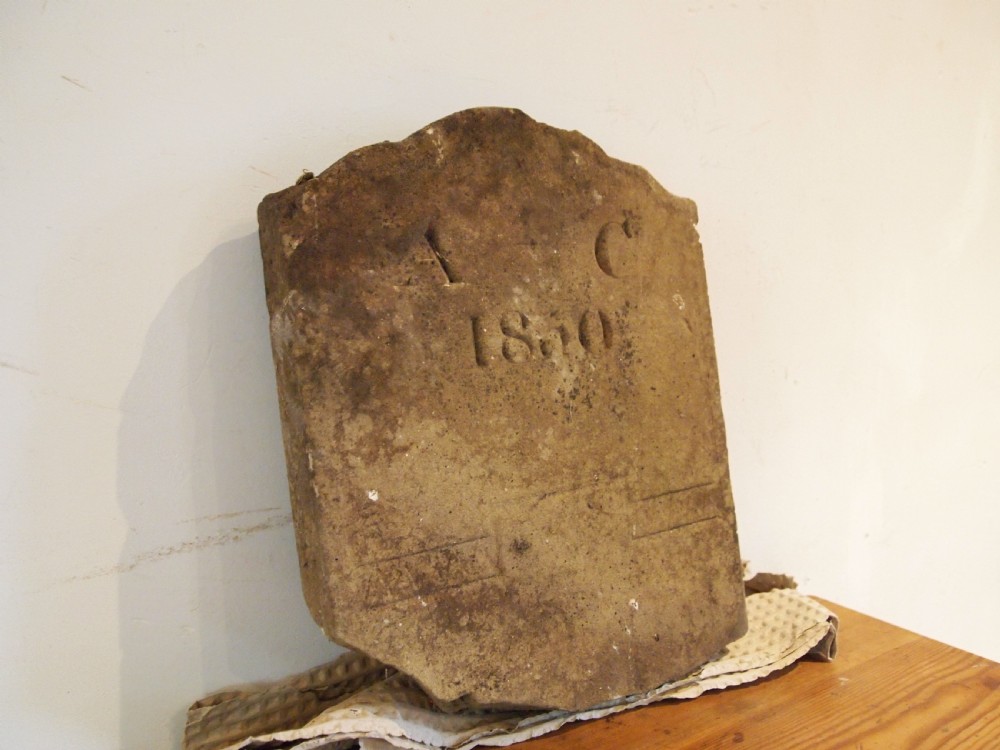 A hand-carved Victorian York stone headstone with chiselled initials A C and date 1860.