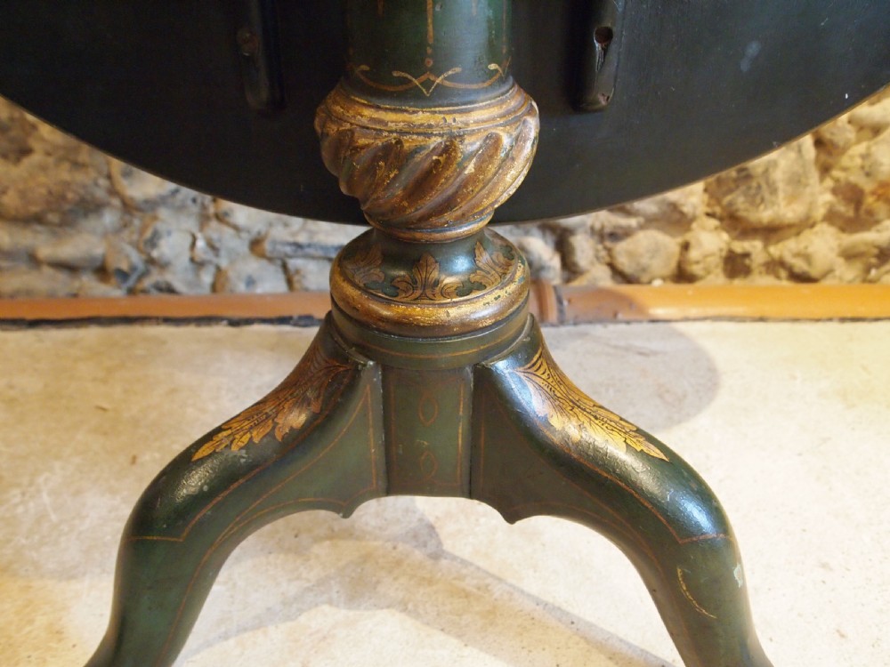 A circular black lacquered tilt-top table featuring intricate gold gilt Chinoiserie cartouches resting on a tripod pedestal base. View VII