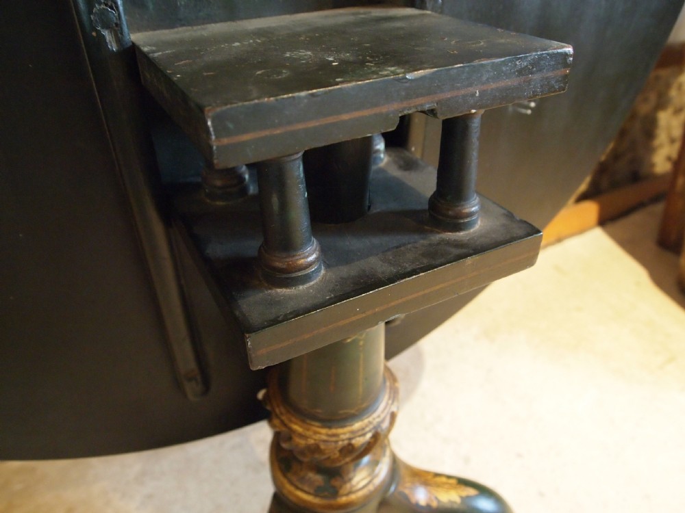 A circular black lacquered tilt-top table featuring intricate gold gilt Chinoiserie cartouches resting on a tripod pedestal base. View VIII