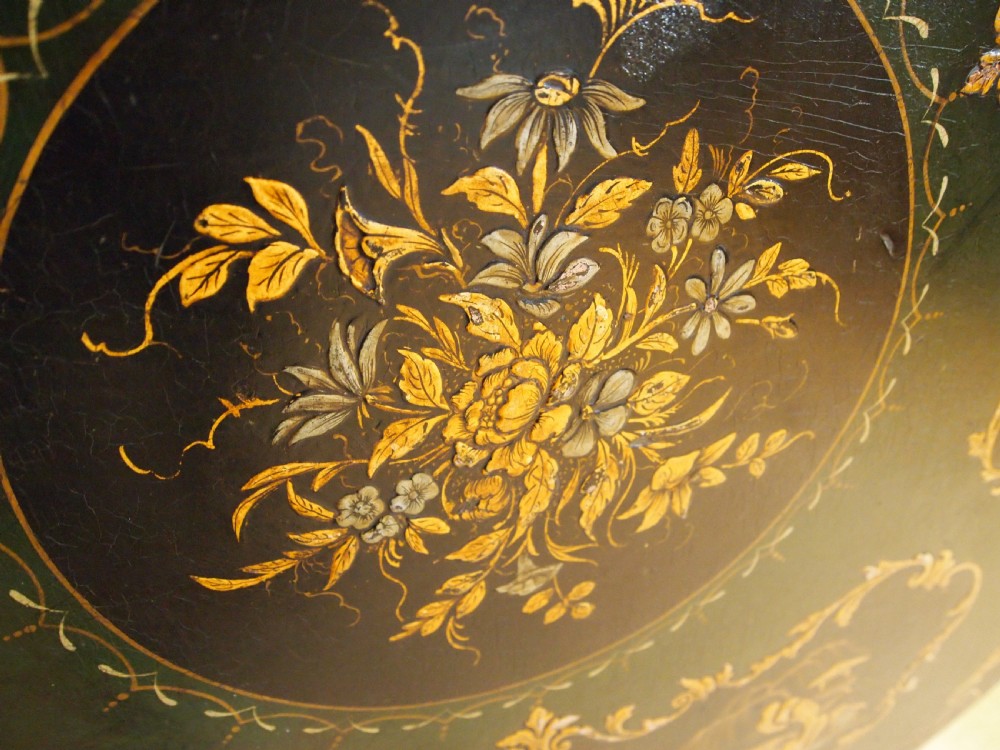 A circular black lacquered tilt-top table featuring intricate gold gilt Chinoiserie cartouches resting on a tripod pedestal base. View X