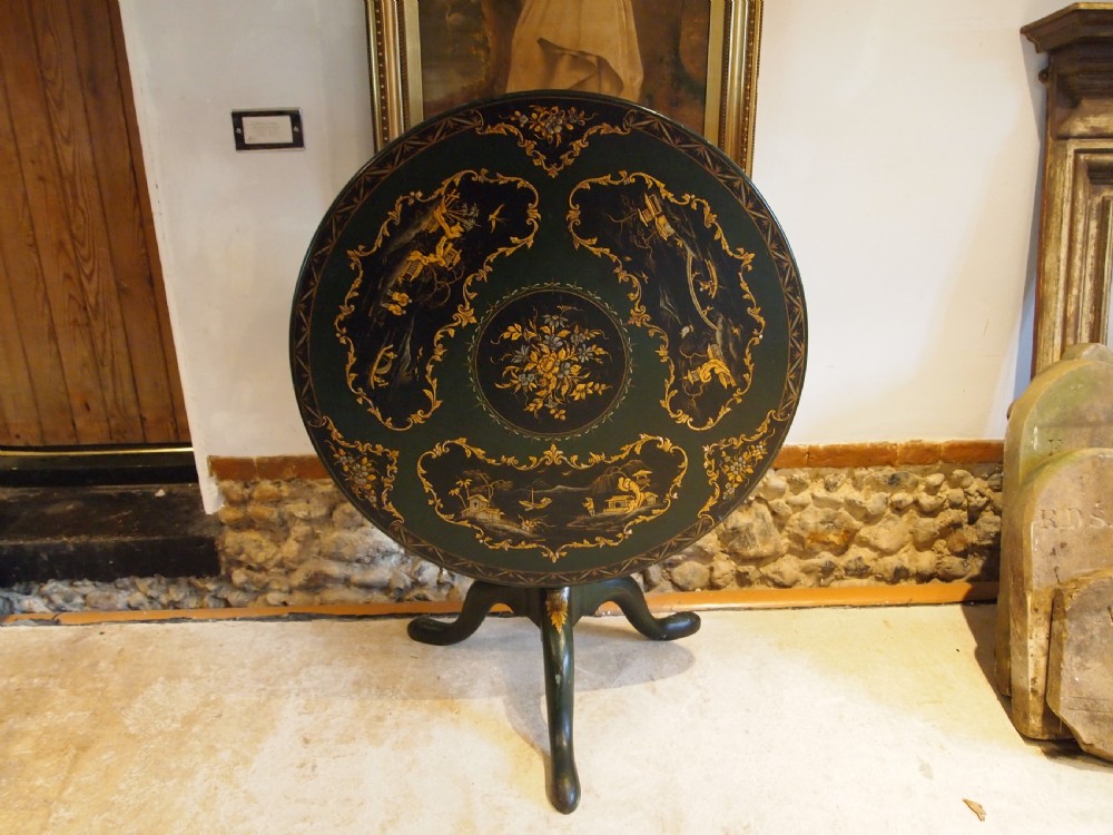 A circular black lacquered tilt-top table featuring intricate gold gilt Chinoiserie cartouches resting on a tripod pedestal base. View XI
