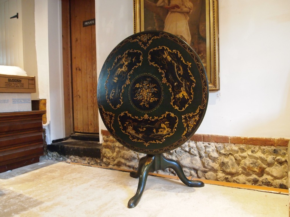 A circular black lacquered tilt-top table featuring intricate gold gilt Chinoiserie cartouches resting on a tripod pedestal base. View XIII