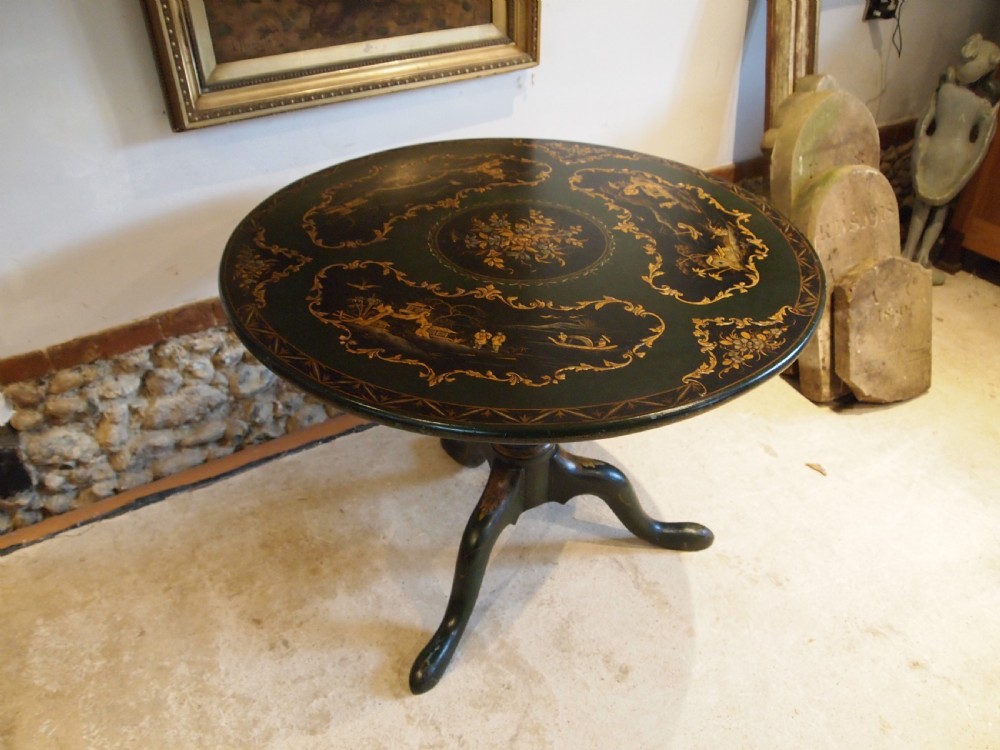 A circular black lacquered tilt-top table featuring intricate gold gilt Chinoiserie cartouches resting on a tripod pedestal base. View XIV
