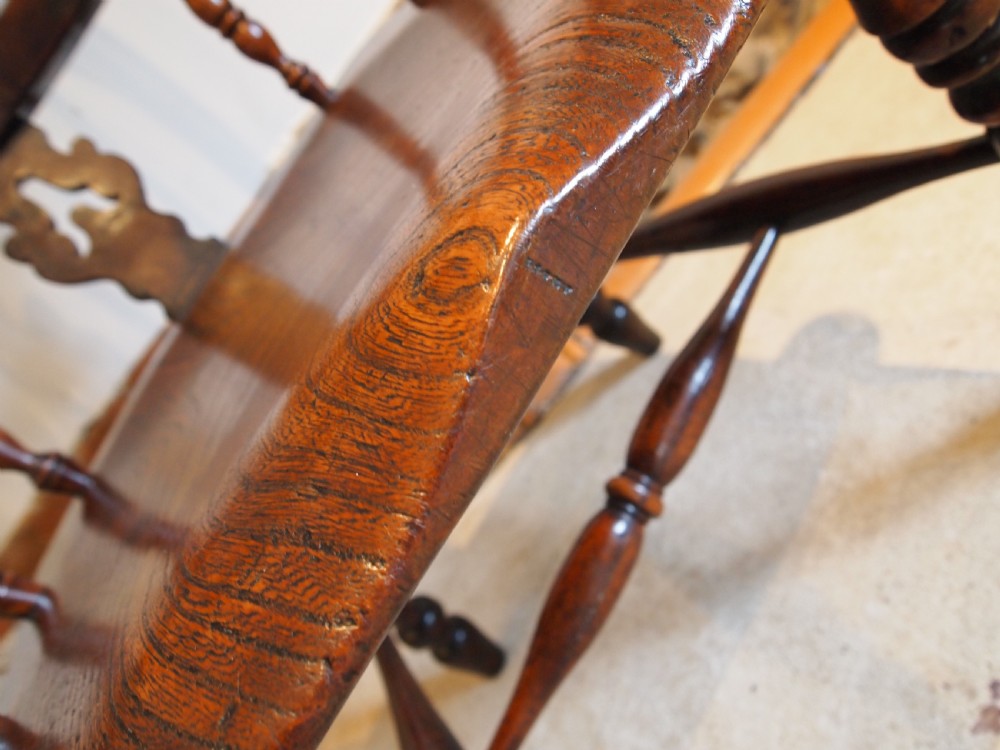 An antique 19th-century yew wood Windsor armchair featuring a bowed top rail, pierced central splat, turned spindles, armrests, and turned legs joined by an H-stretcher. View V