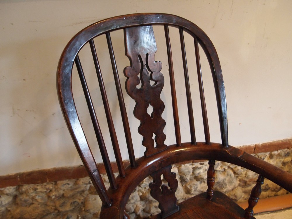 An antique 19th-century yew wood Windsor armchair featuring a bowed top rail, pierced central splat, turned spindles, armrests, and turned legs joined by an H-stretcher. View VI