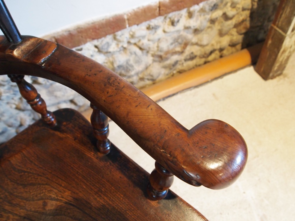 An antique 19th-century yew wood Windsor armchair featuring a bowed top rail, pierced central splat, turned spindles, armrests, and turned legs joined by an H-stretcher. View VII