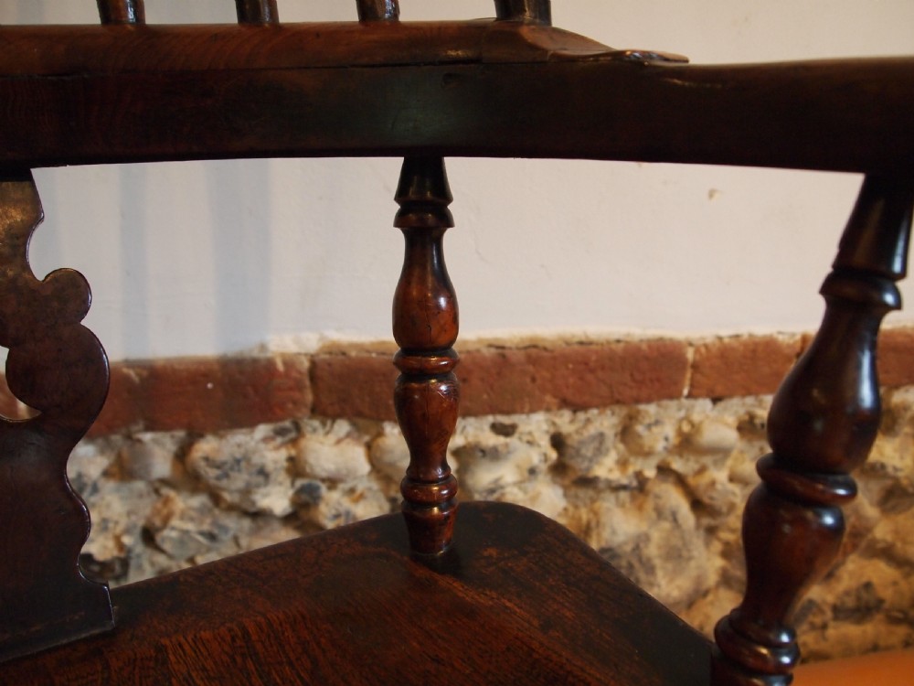 An antique 19th-century yew wood Windsor armchair featuring a bowed top rail, pierced central splat, turned spindles, armrests, and turned legs joined by an H-stretcher. View VIII